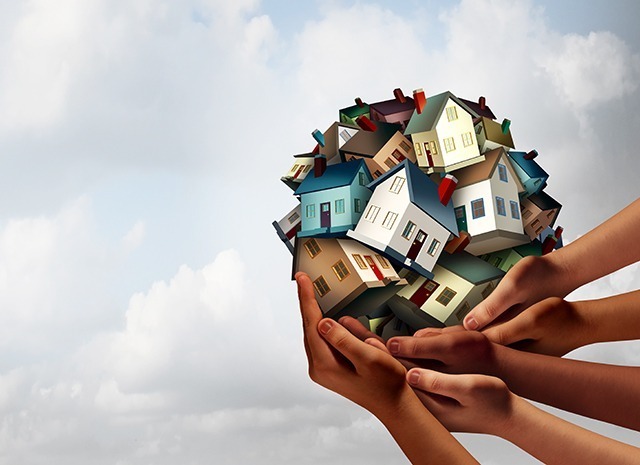 Social Housing Concept And Supportive Home Ownership Symbol As A Group Of Diverse Hands Holding Many Family Homes As A Metaphor For Supporting Neighborhood Togetherness.