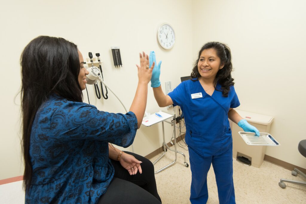 Gloria Cruz high-fiving a patient