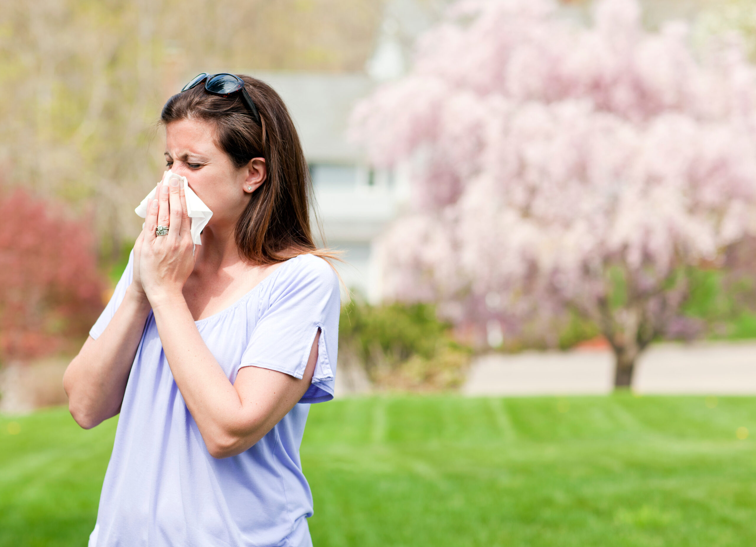 Woman Outside Blowing Nose With A Tissue